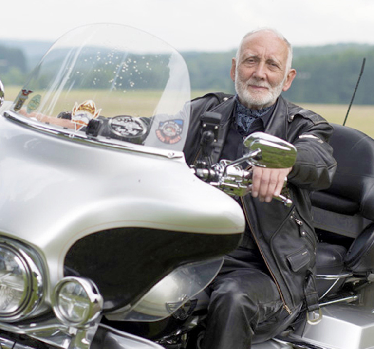 Man on a motorcycle with sidecar.