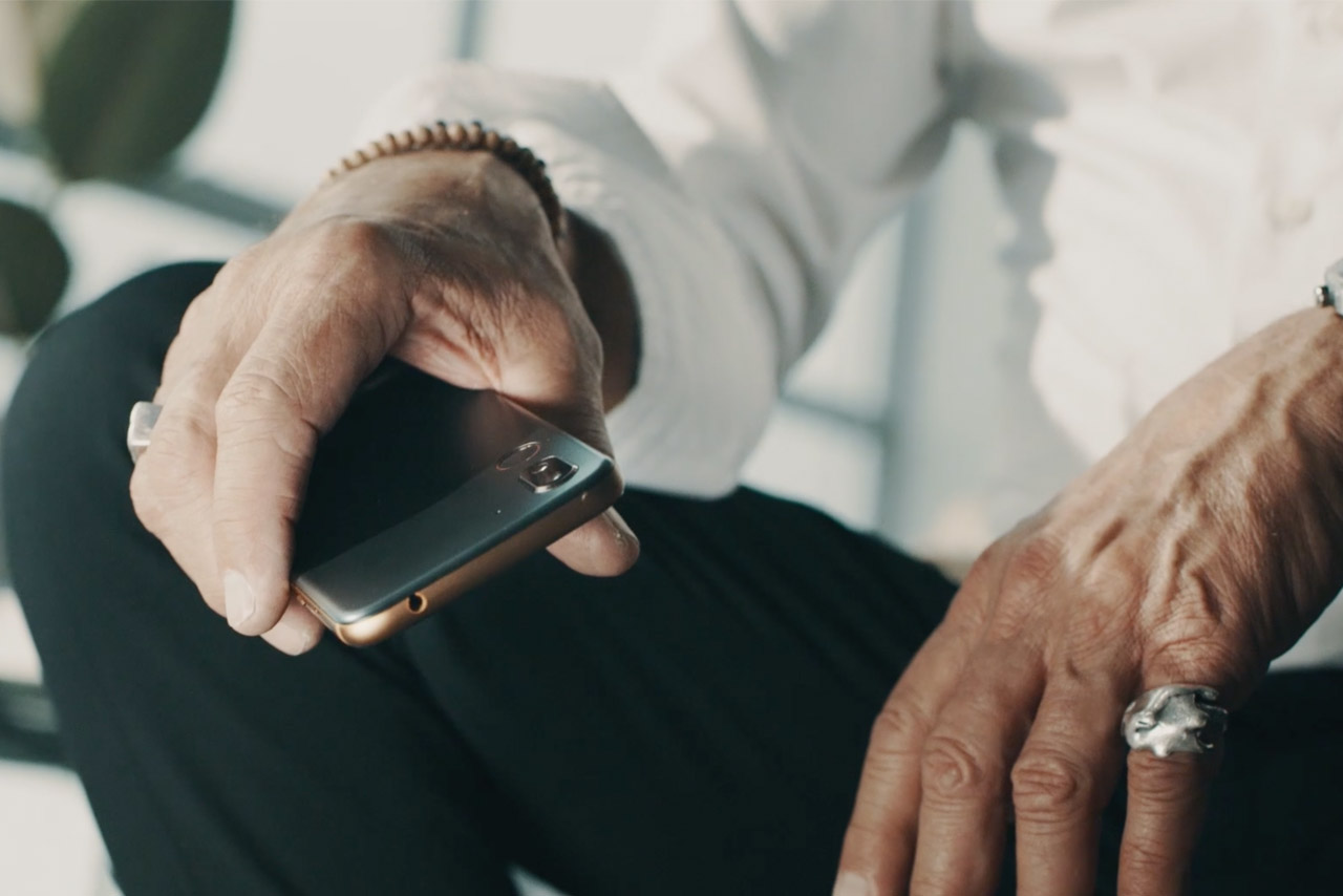 Senior holding smartphone with ergonomic design in hand