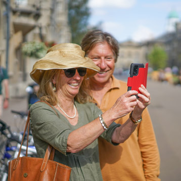 Senior couple taking photo outdoors using Doro smartphone with easy-to-use camera