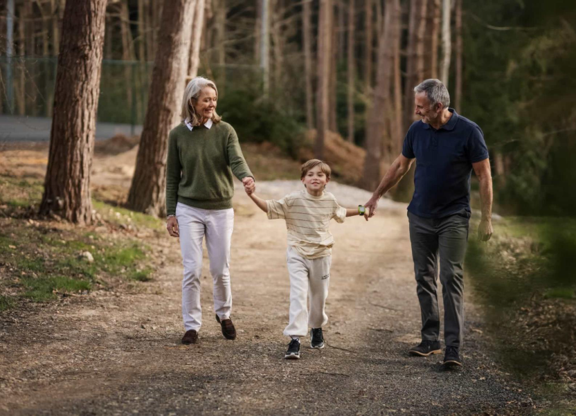 Un jeune garçon se promenant avec ses grands-parents dans la forêt.