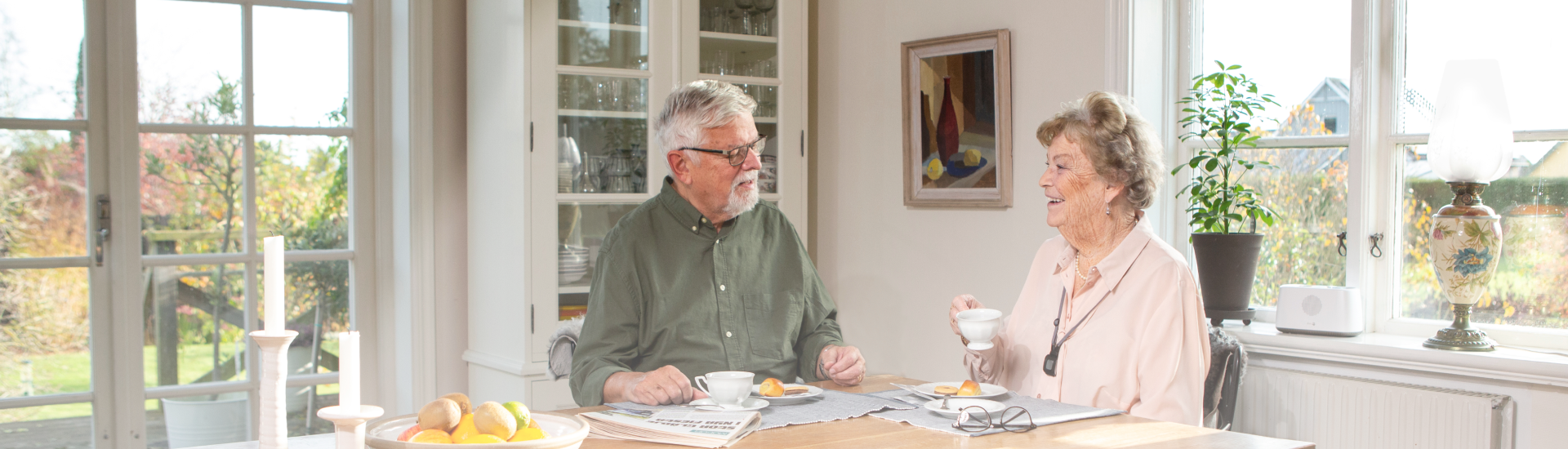 Two seniors having coffee in the kitchen