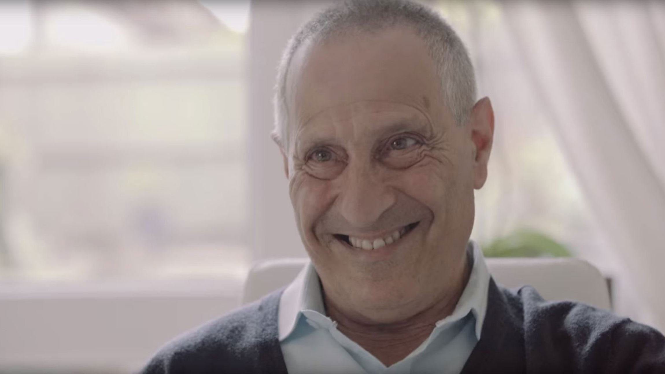 Smiling older man indoors representing Doro users enjoying simple technology
