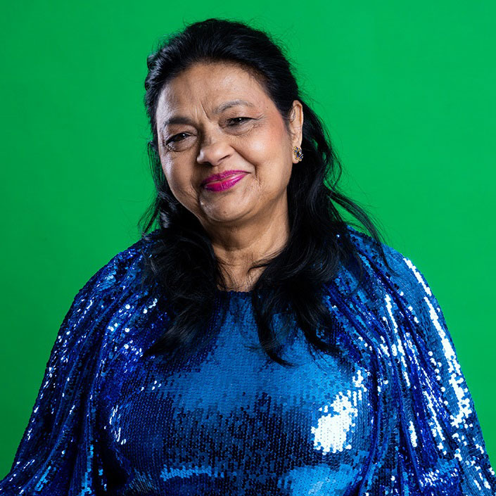 Leende självsäker senior kvinna mot en grön bakgrund, representerar en positiv aktiv livsstil