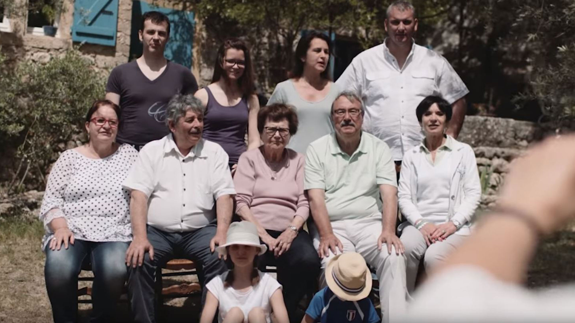 Multi-generational family with seniors, adults and children posing together outdoors
