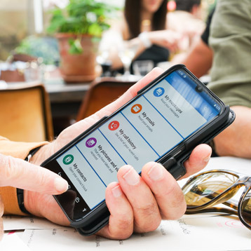 Person holding a smartphone with apps displayed on screen