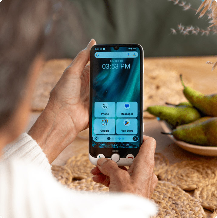 Senior using Doro smartphone with easy interface showing large icons for calls and messages