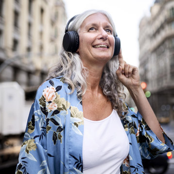 Kvinde med hovedtelefoner, der lytter til lyd udendørs