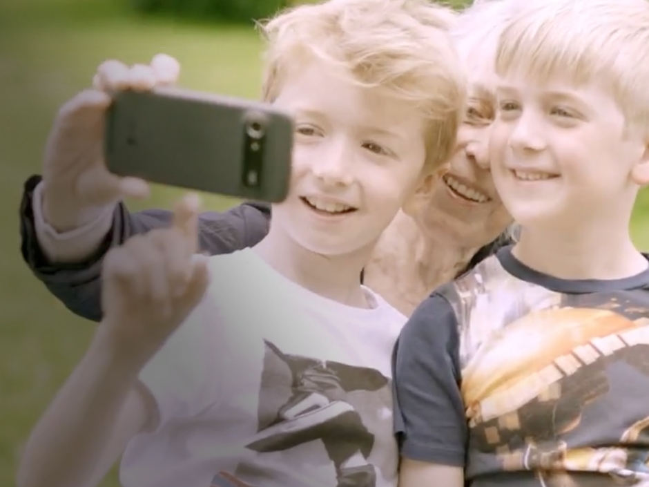 Woman snapping selfie with her grandchildren.