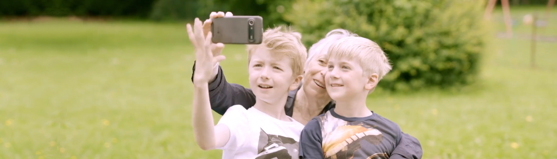 Nainen ottamassa selfietä lastenlastensa kanssa.