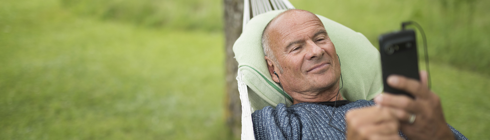 Lasse Holm in hammock using a Doro smartphone.