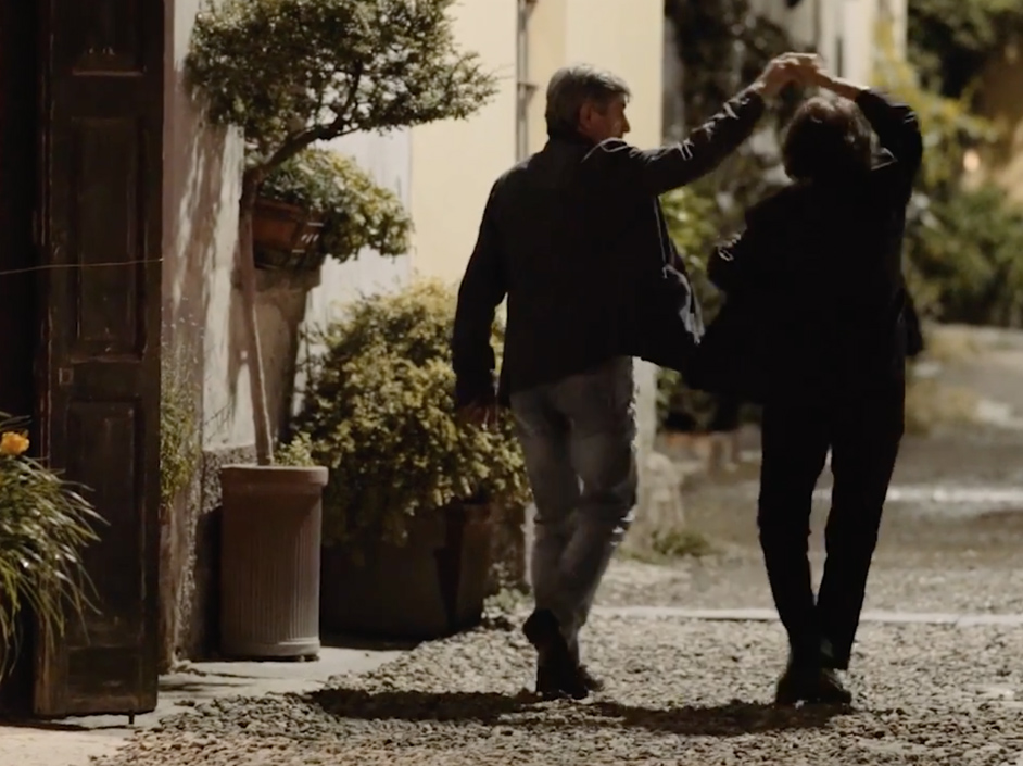 Couple dancing on gravel path.