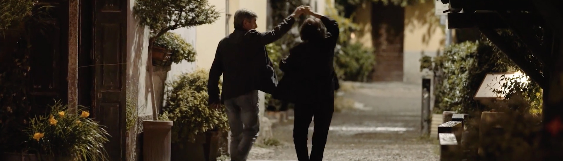 Couple dancing on gravel path.