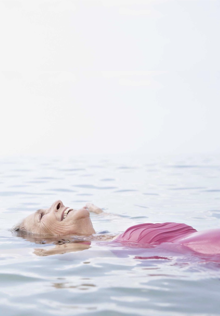Mujer feliz flotando en el mar.