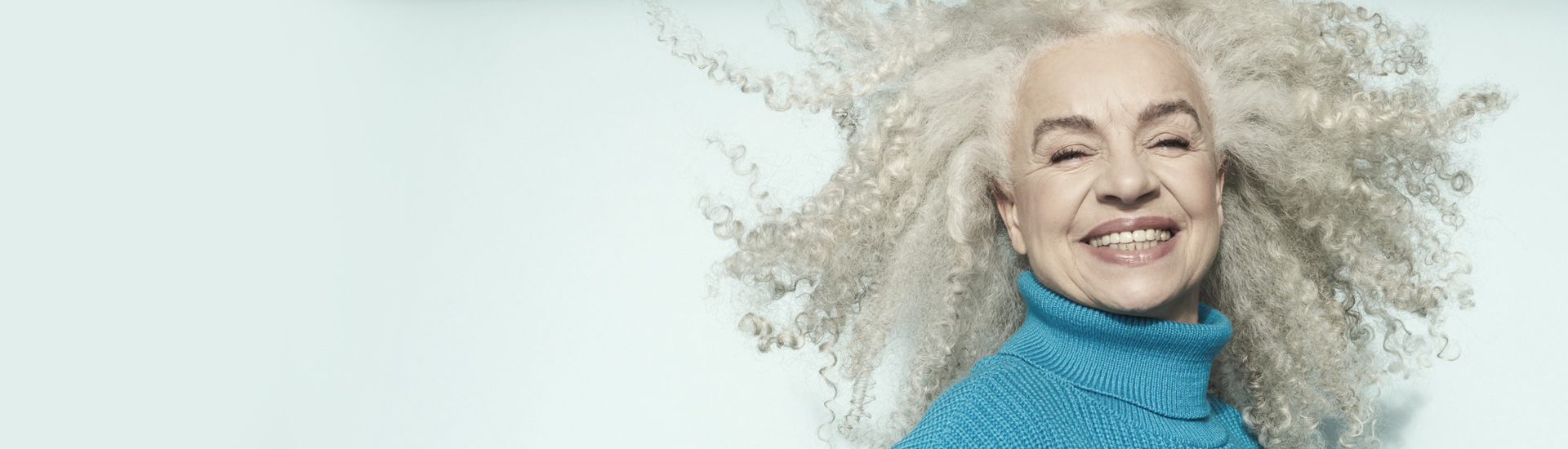 Smiling woman with corkscrew curls. 