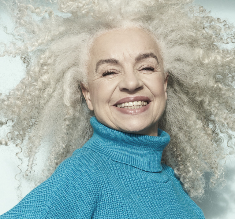 Donna sorridente con i capelli a boccoli. 