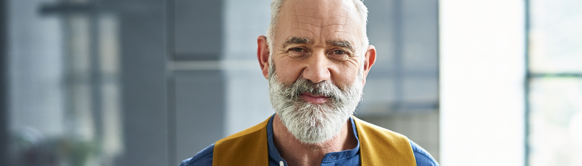 Hombre con camisa azul y chaleco.