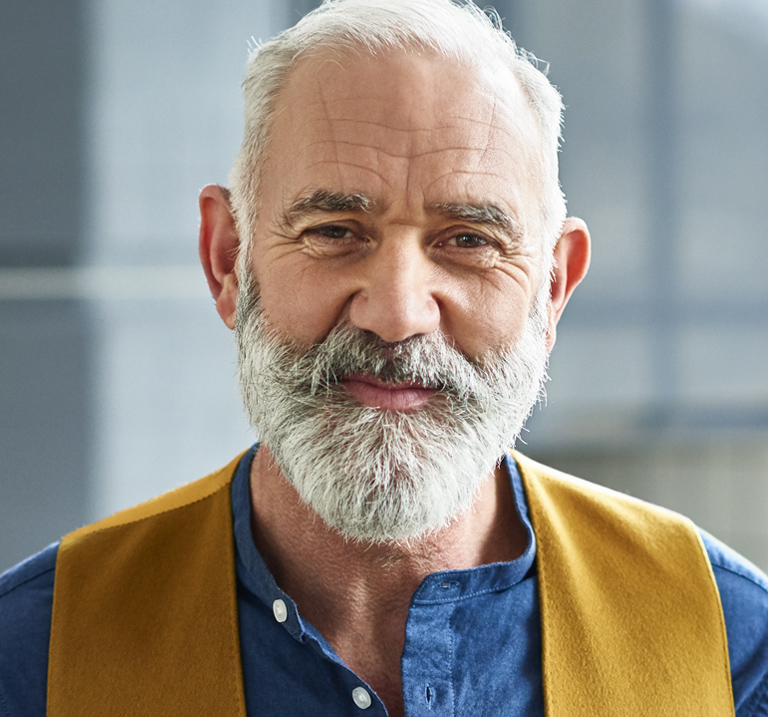 Uomo con camicia blu e gilet.