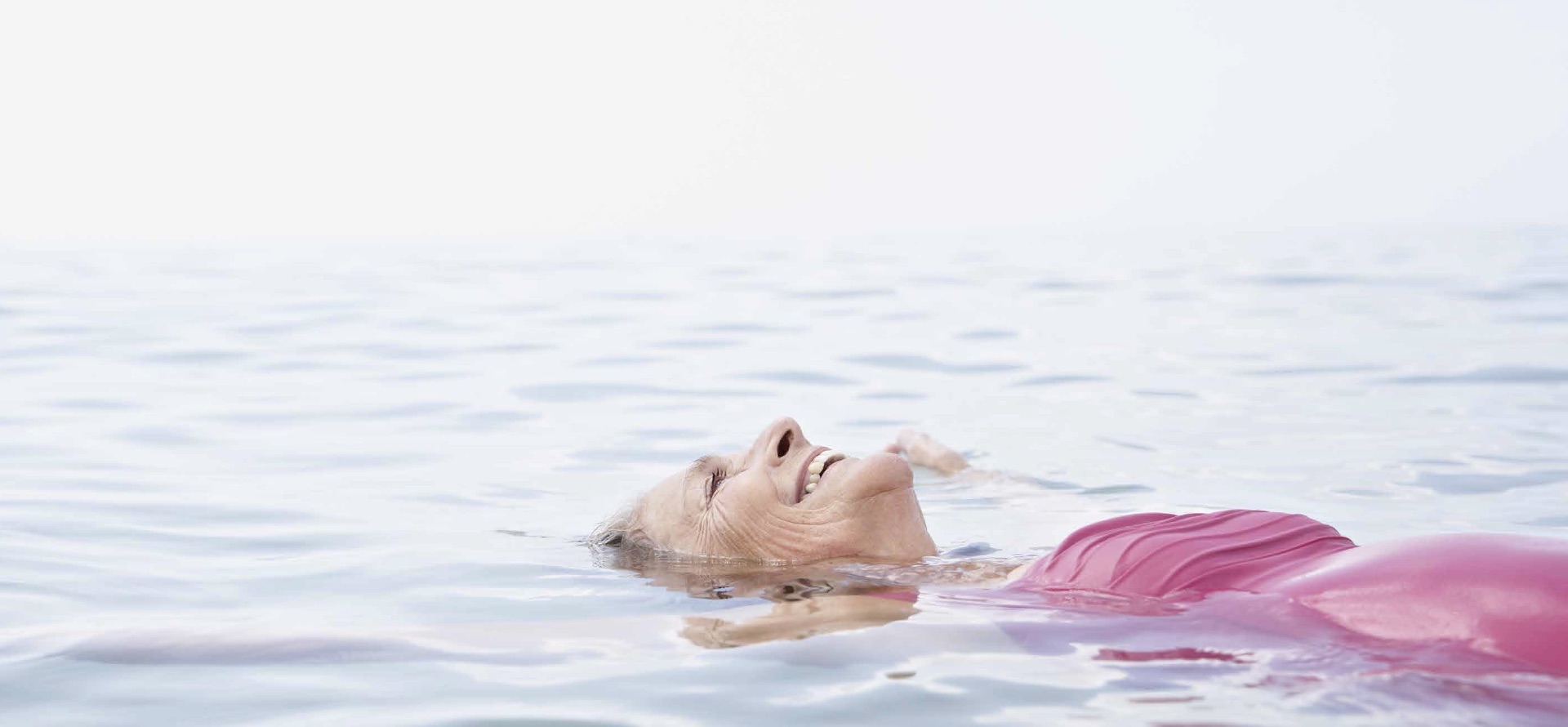 Mujer feliz flotando en el mar.