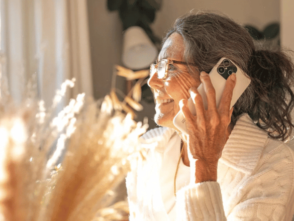 Une dame âgée au téléphone utilisant l'application Xplora Senior