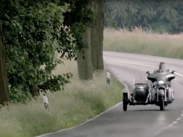 Motocicletta con sidecar su una strada di campagna.