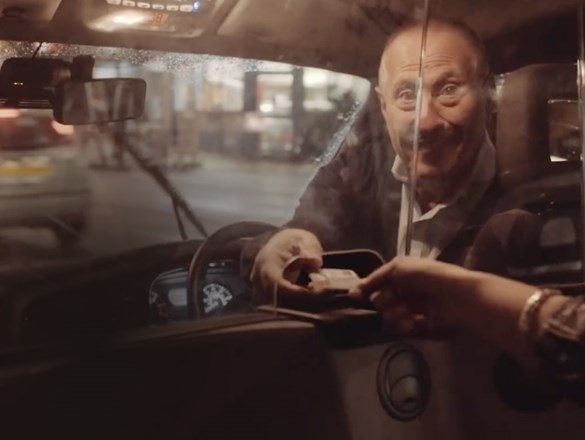 Taxichaufför tar emot betalning.