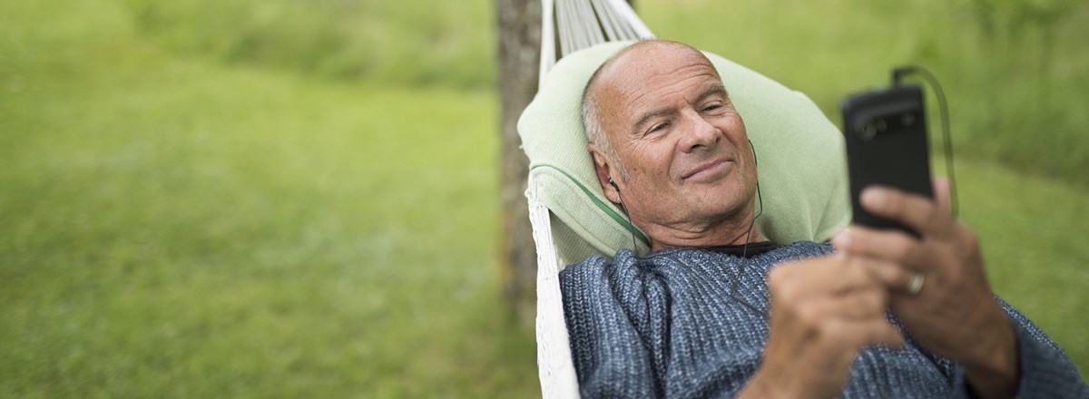 Lasse Holm in hammock using a Doro smartphone.